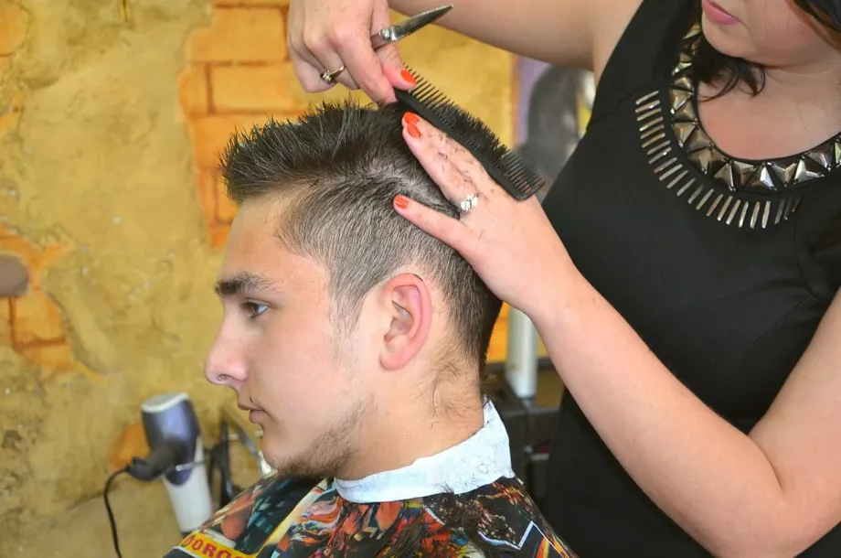 Una peluquera peinando a su cliente
