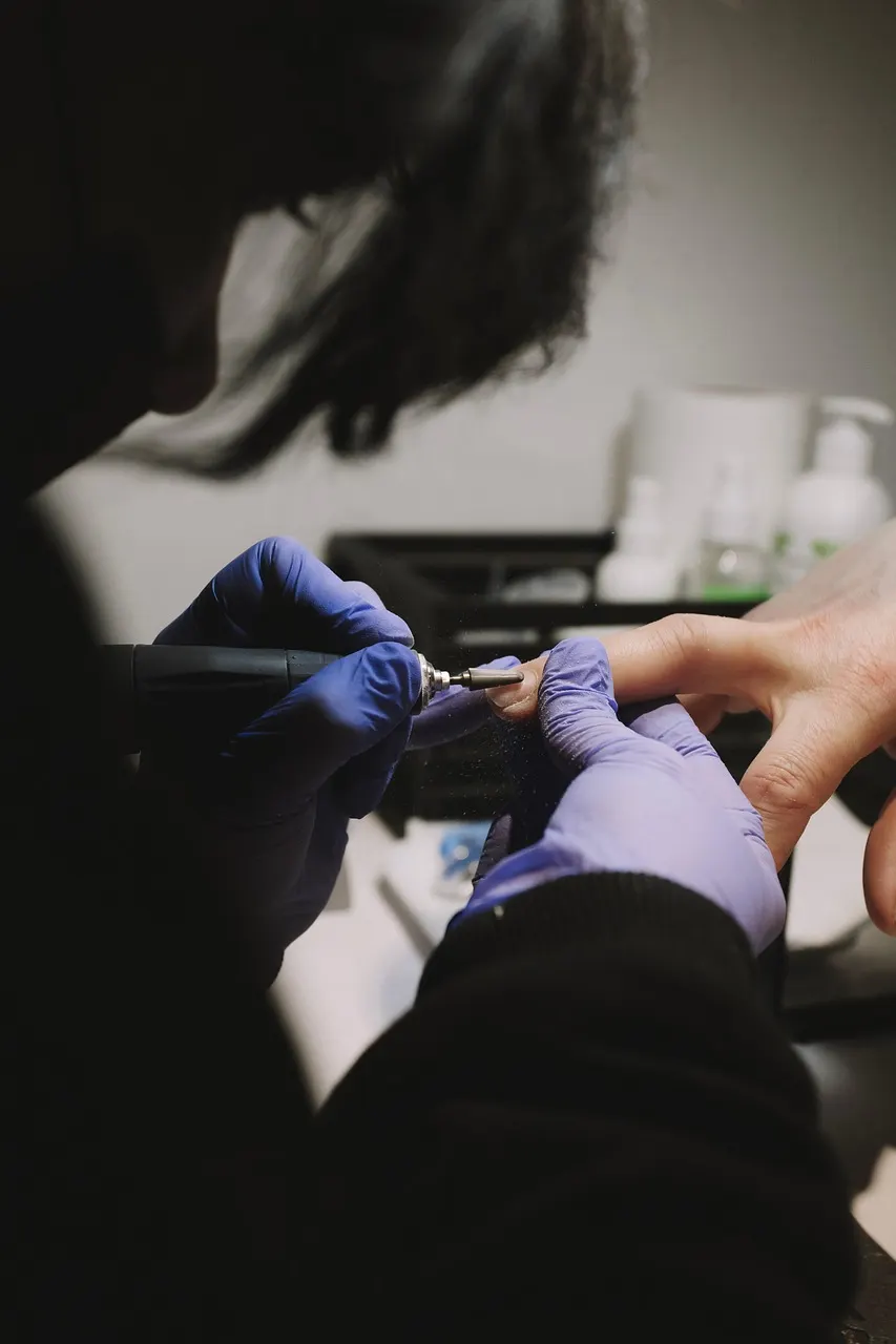 A manicurist with her client